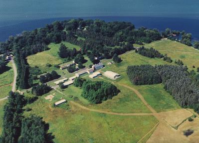 Farm buildings surrounded by green fields near water